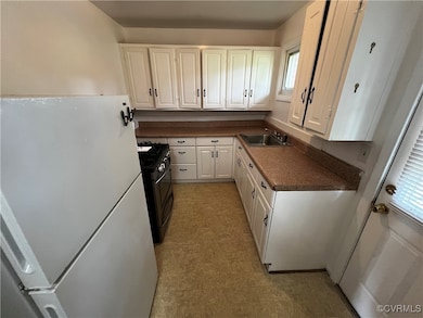 Kitchen featuring freestanding refrigerator, gas s