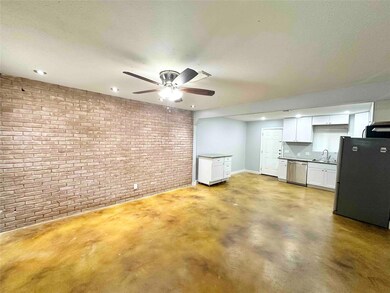 Unfurnished living room with brick wall, a sink, 