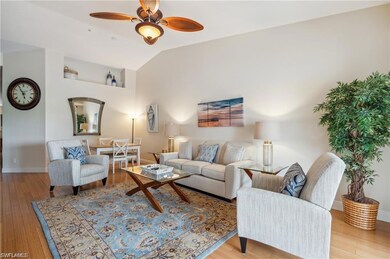 Living room with vaulted ceiling, ceiling fan, and