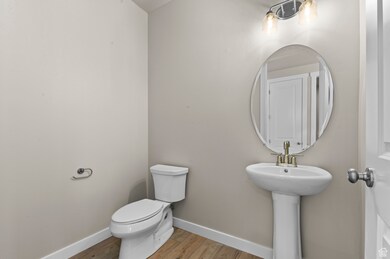 Half bath with baseboards and light wood-type flooring
