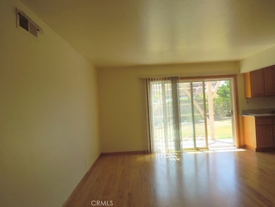 Large family room with beautiful wood floors! Looks out to side yard with patio. Opens to kitchen.