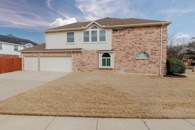 View of front facade with concrete driveway, brick