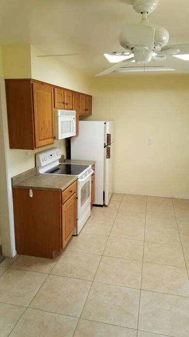 Tiled kitchen w/refrigerator.