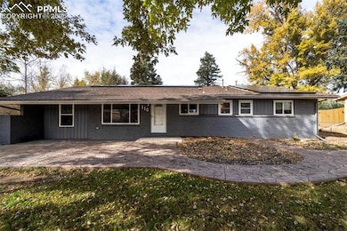 Ranch-style home with brick siding and concrete patio with path to backyard