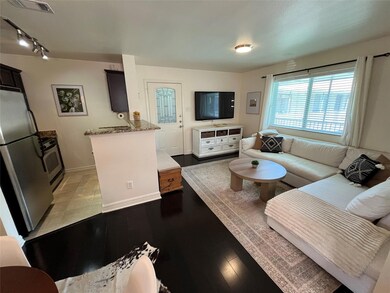 Living area with rail lighting and light wood fin