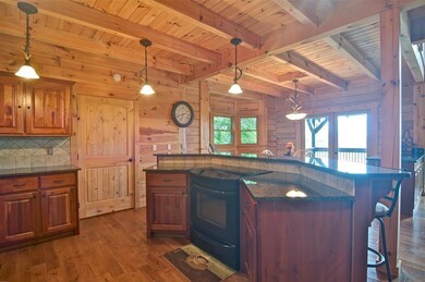 Kitchen with a wood ceiling with exposed beams, wooden walls, dark wood-style flooring, a breakfast bar, and black electric range oven