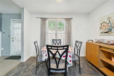 Dining space with a textured ceiling and dark wood-type flooring