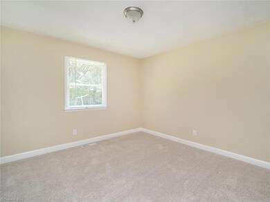 Large bedroom overlooking backyard with new carpet.