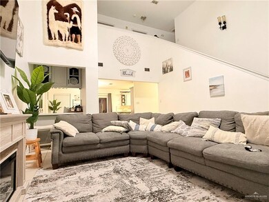 Living area featuring a towering ceiling and a glass covered fireplace