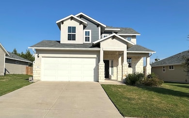 View of front of property with stucco siding, a front yard, and concrete driveway