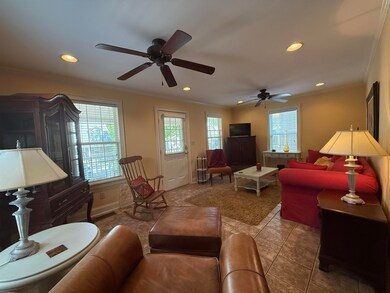 Tiled living room featuring baseboards, recessed l