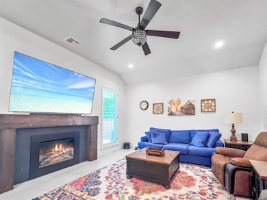 Living room featuring ceiling fan, lofted ceiling, recessed lighting, and a fireplace with flush hearth