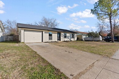 Single story home featuring a front yard and a gar