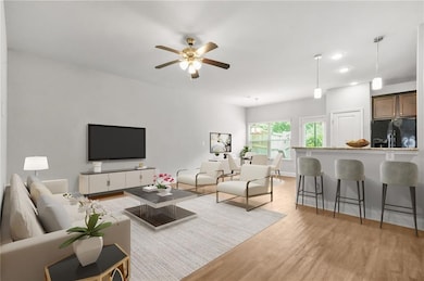 Living room featuring light wood-style flooring, ceiling fan, and recessed lighting