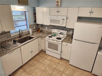 Kitchen featuring white cabinetry, white appliance