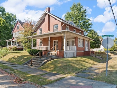 Home featuring a porch, a front lawn, and a chimney