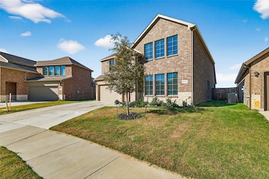 Traditional home featuring brick siding, driveway, and a garage