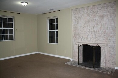 Great sized living room features a rustic brick fireplace as its focal point. This picture was taken before the new carpet was installed.There is brand new carpet through out the house!