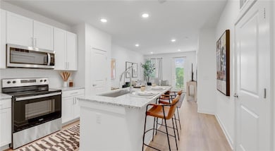 Kitchen with stainless steel appliances, sink, lig
