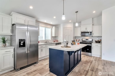Generous counter space, recessed lighting, a large decorator center island with pendant lighting, walk-in pantry and stainless appliances make this a top notch kitchen.  Gas cooktop, Frig with water/ice in the door.  Room for stools under counter extension of kitchen island provide even more seating.