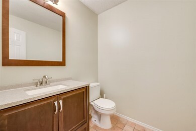 Half bath with vanity, light tile patterned flooring, and a textured ceiling