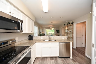 Kitchen featuring a peninsula, appliances with sta