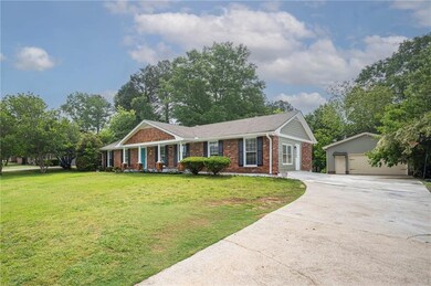 Ranch-style house with an outbuilding, brick sidin