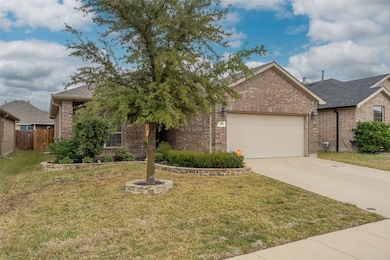 View of front of house featuring brick siding, a front yard, concrete driveway, and roof with shingles