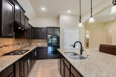 Kitchen featuring black appliances, arched walkwa