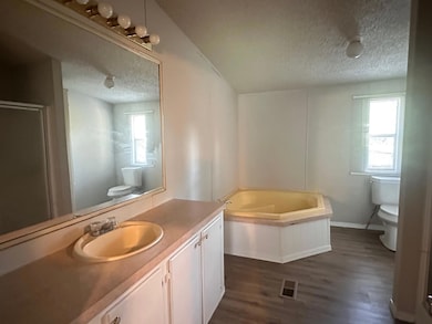 Full bathroom with a textured ceiling, a bath, va