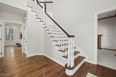 Staircase with wood finished floors and baseboards