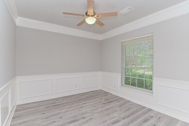 Dining room with wainscoting and crown molding. Fresh interior paint and Luxury Vinyl Plank flooring!