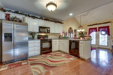 Spacious kitchen features gleaming hardwood flooring, breakfast bar and an eat in dining area.