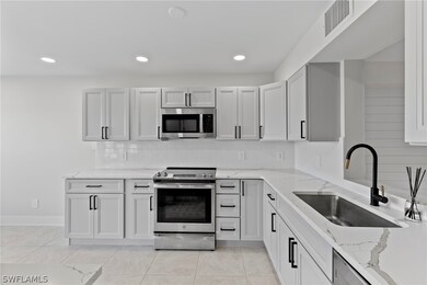 Kitchen featuring sink, light stone countertops, l