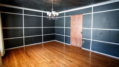 Unfurnished bedroom with wood-type flooring and a chandelier