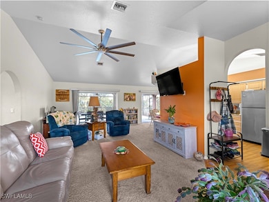 Living room with visible vents, vaulted ceiling, a