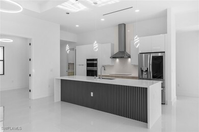 Kitchen featuring wall chimney range hood, applian