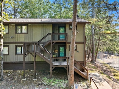Rear view of property with stairway, a shingled roof, and a deck
