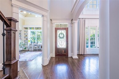 Foyer entrance with ornate columns, a towering cei