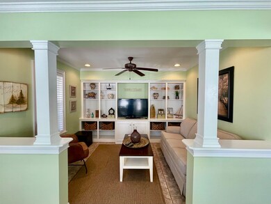 Living area featuring crown molding, decorative co