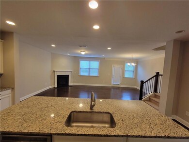Kitchen with a sink, light stone counters, a tile 