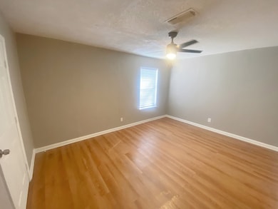 Empty room featuring a textured ceiling and wood finished floors