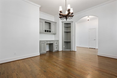 The spacious layout easily accommodates large office furniture with room to spare. A built-in display cabinet offers the perfect spot to showcase your favorite pieces, while a striking chandelier adds an elegant finishing touch.