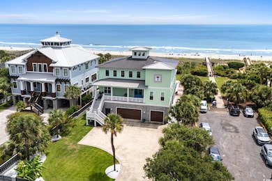 View of front of house featuring a metal roof, a standing seam roof, stairs, view of water and beach, and a balcony