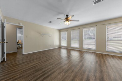 Unfurnished living room with a ceiling fan and dar