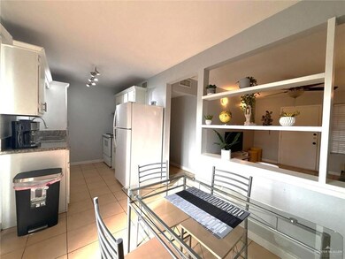 Kitchen featuring built in features, light tile patterned floors, white appliances, white cabinetry, and a sink