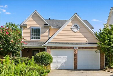 Traditional-style home with brick siding, a garage, driveway, and a shingled roof