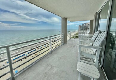 Balcony with view of water and beach