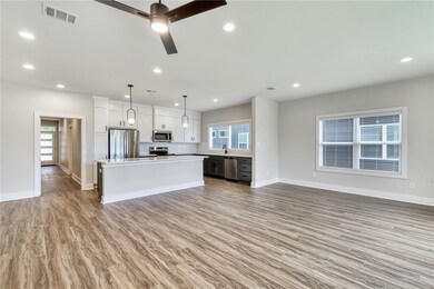 Kitchen with open floor plan, appliances with stai