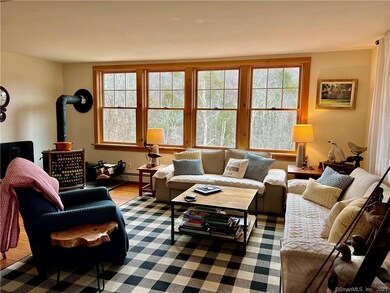 Charming living room with views of the yard and ri